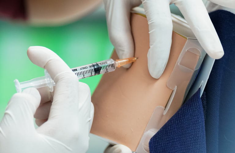 Foundation Immunisation Training A hand administering an injection into a medical training prosthetic.