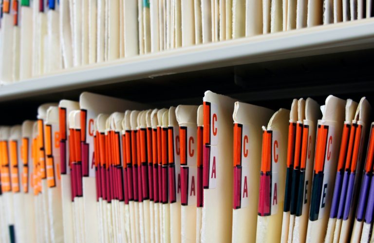 Clinical Records A close-up of labelled file folders neatly arranged on a shelf.