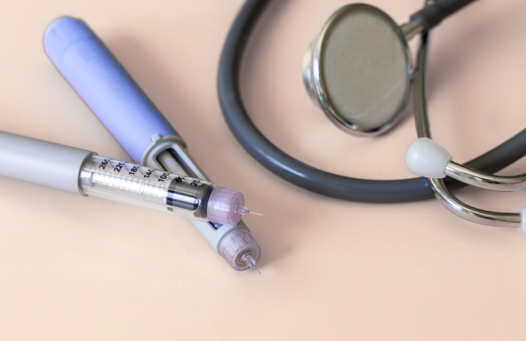 Blood Glucose Monitoring and Insulin Administration Medical instruments including a stethoscope and pen-like devices on a light background.