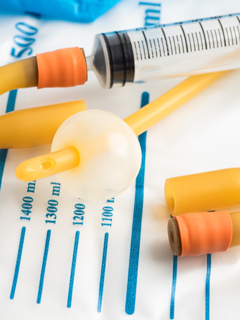 Catheterisation Kit Medical equipment including a syringe and various caps on a sterile surface.