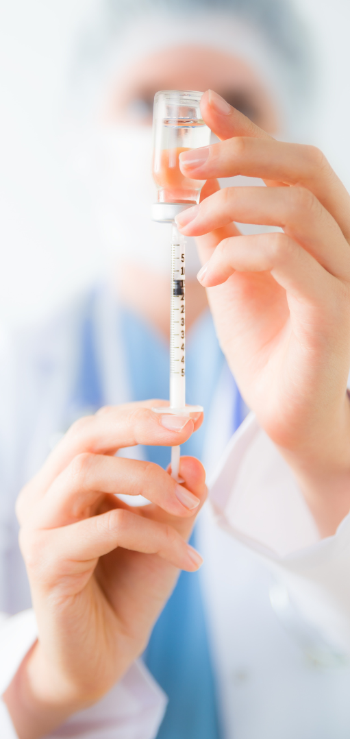 Vaccination A healthcare professional holding a syringe ready for use.