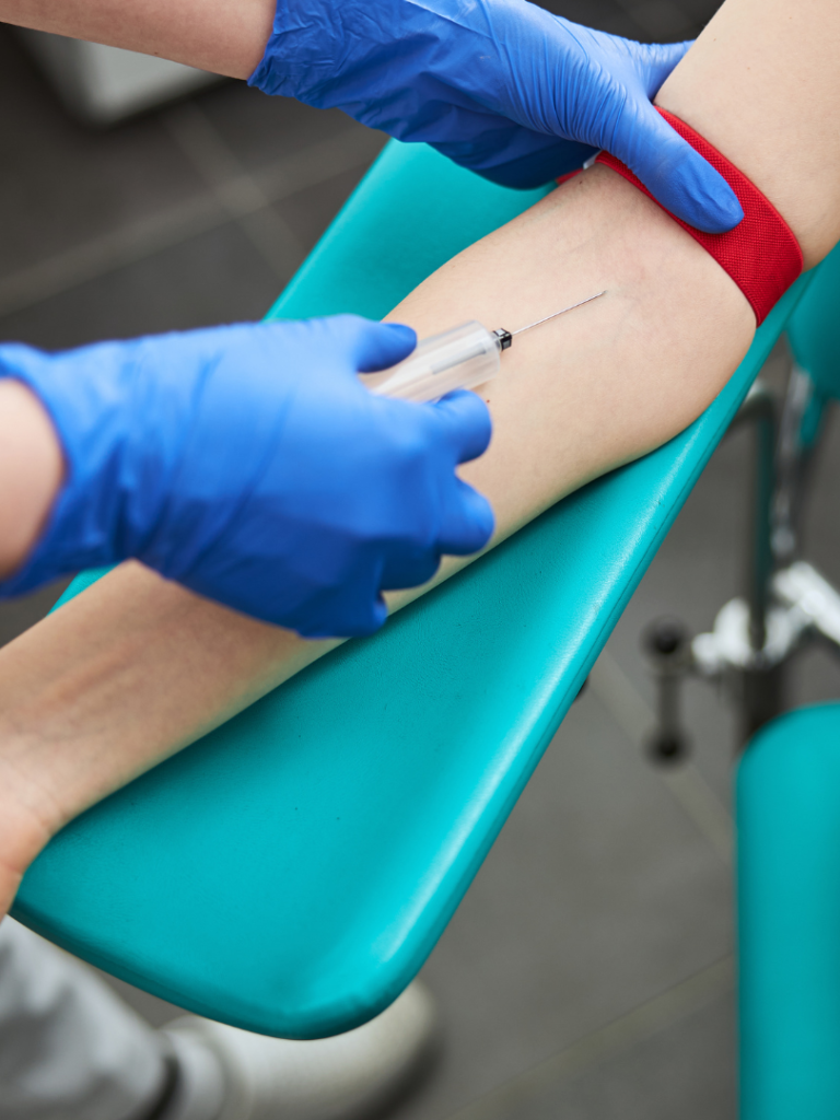 Venepuncture procedure A healthcare professional preparing to extract blood from a patient's arm.